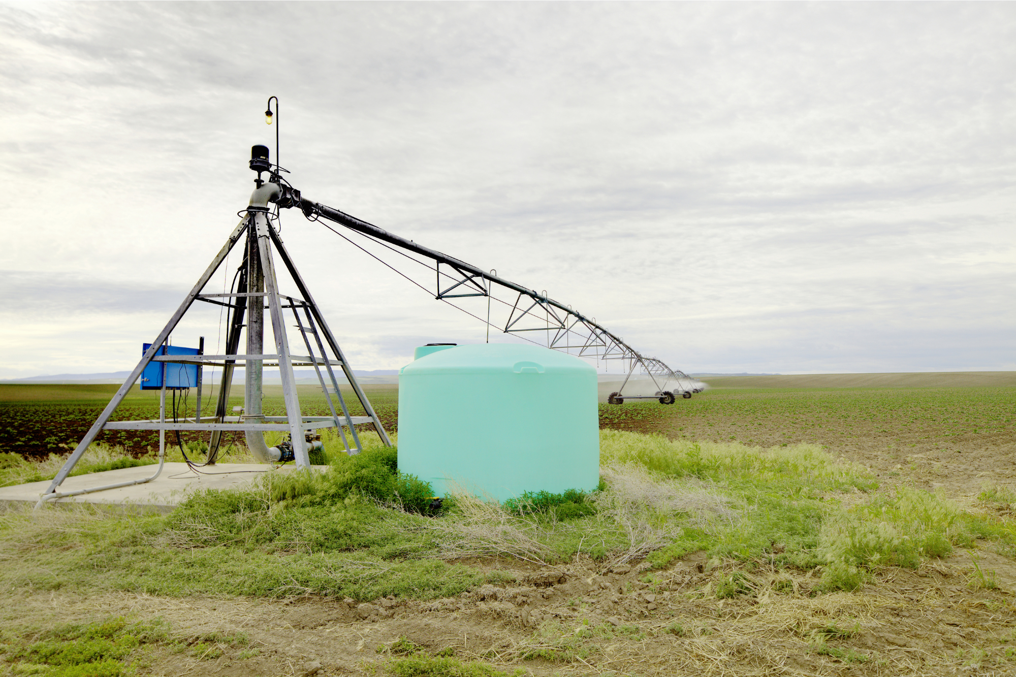 Irrigation system with a fertilizer tank mixing chemicals into water for fertigation